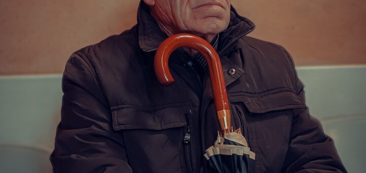 Older man sitting with cane