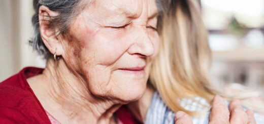 Older Woman in red Sweater hugging granddaughter
